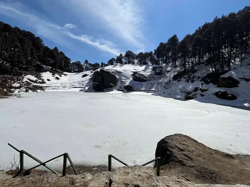 ourist relaxing by the peaceful Serolsar Lake in Jibhi